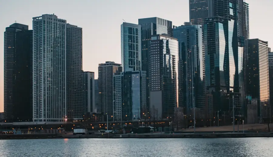 Chicago Illinois downtown skyline at dusk viewed from the waterfront with illuminated skyscrapers reflecting evening light
