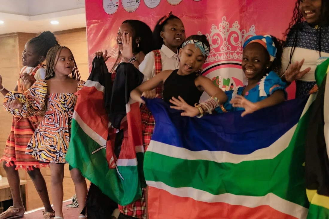 Young people joyfully celebrating African American heritage and freedom with flags at a Juneteenth cultural celebration