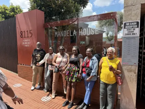 Group of six visitors posing at Mandela House; 8115 Vilakazi St; Orlando West; Soweto; during eat-mea-2026 tour.