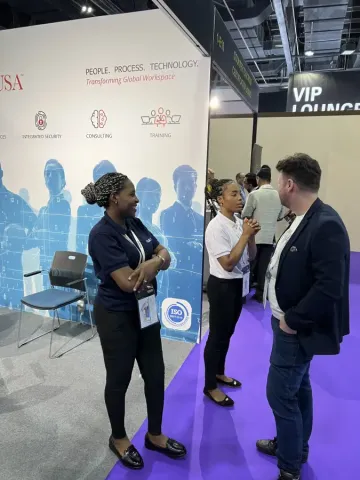 Three professionals networking at the LABUSA USA booth at Intersec; discussing integrated security and consulting services.