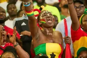 A woman dressed in ghana\\\'s colors cheering