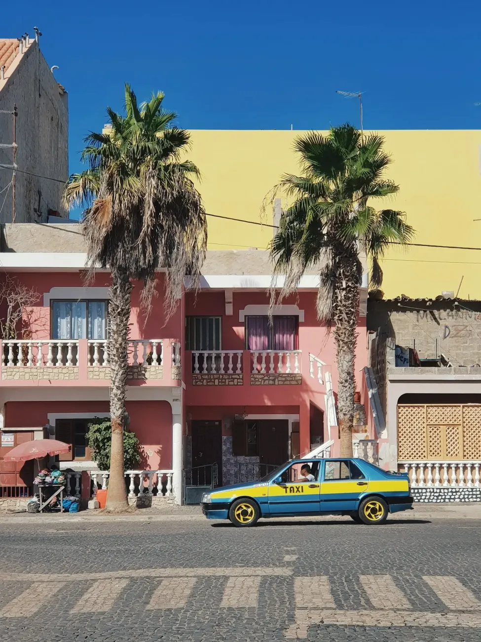 Blue and yellow taxi on a street