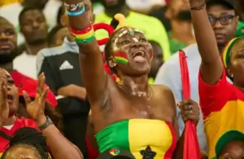 A woman dressed in ghana\\\'s colors cheering