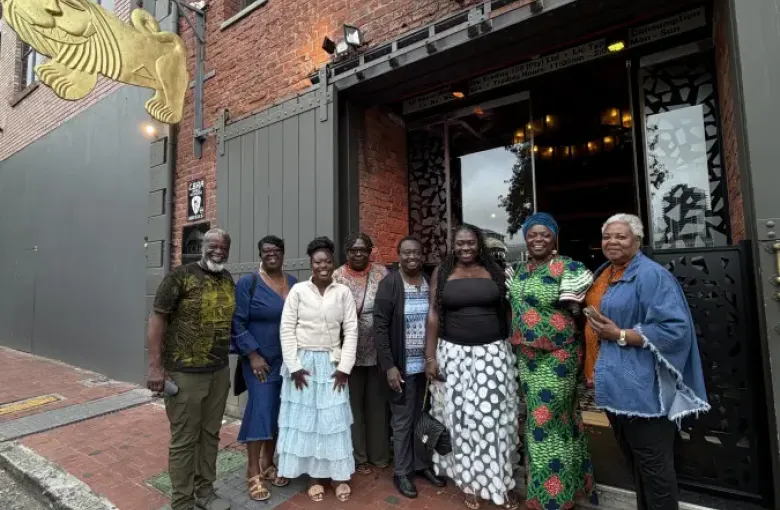 Group of eight professionals posing outside Gold Restaurant entrance for eat-mea-2026 dining event in Cape Town.