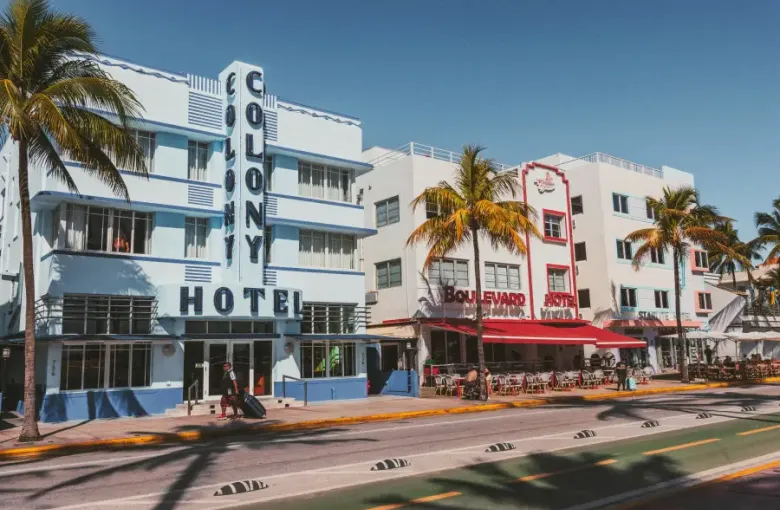 Art Deco Colony and Boulevard hotels line Ocean Drive in Miami Florida under clear blue skies with palm trees.