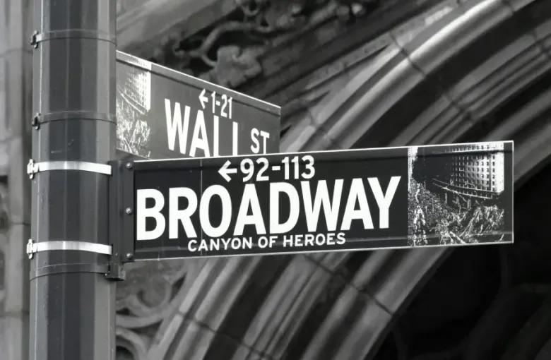 Street signs marking Broadway Canyon of Heroes and Wall St intersection in Lower Manhattan New York New York in black and white photograph