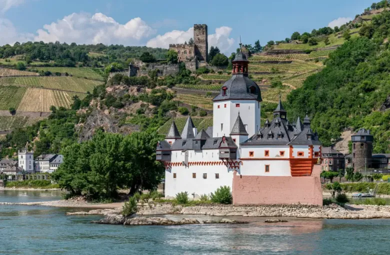 River cruise destination: Pfalzgrafenstein Castle on Rhine Island with Gutenfels Castle on vineyard hillside; Germany.
