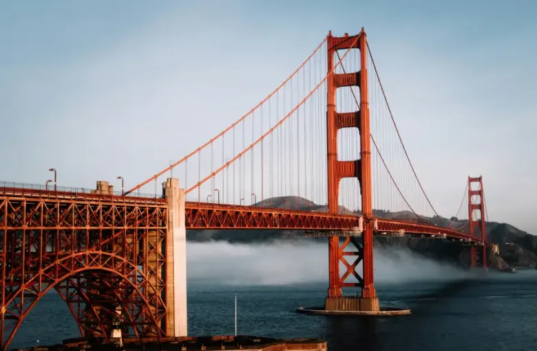 Golden Gate Bridge in san-francisco-ca with low fog rolling across the bay beneath the iconic red suspension towers.