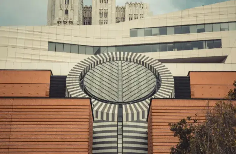 SFMOMA's striped cylindrical skylight rises above red brick facade with Gothic towers of a historic san-francisco-ca build