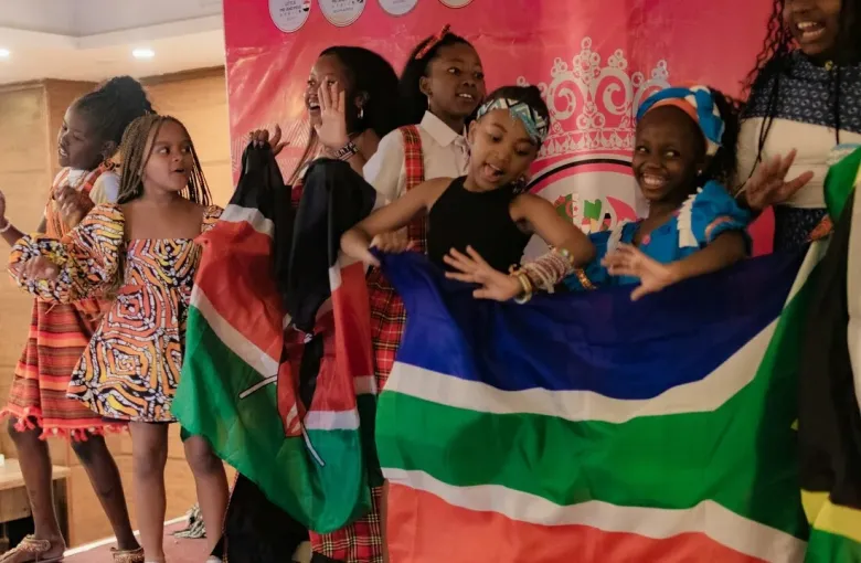Young people joyfully celebrating African American heritage and freedom with flags at a Juneteenth cultural celebration
