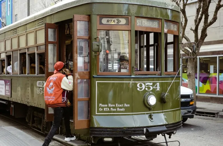 The historic green St. Charles Avenue streetcar picking up a passenger in New Orleans