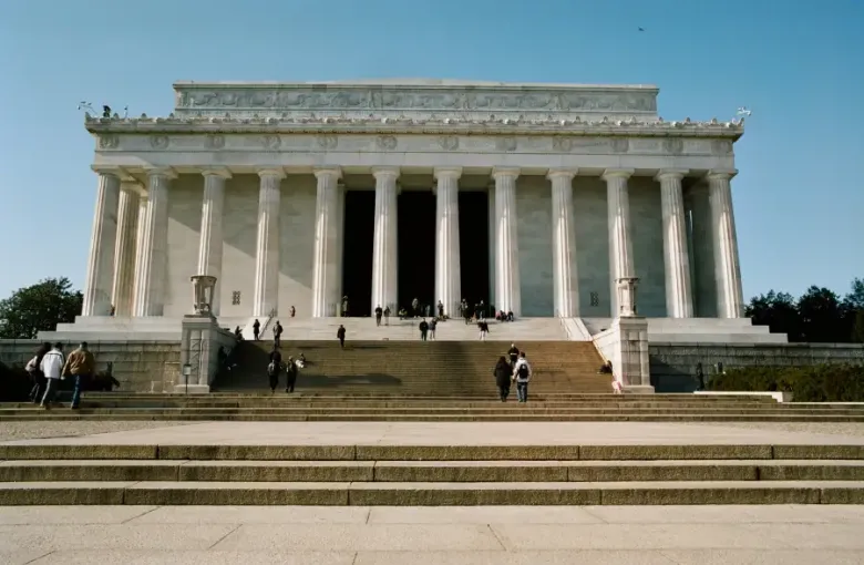 Visitors climbing the broad stone steps of the Lincoln Memorial in Washington; DC on a clear sunny day.