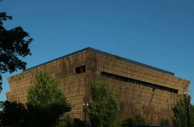 The bronze latticed exterior of the National Museum of African American History and Culture in Washington; DC; under a cle